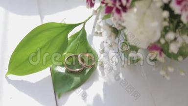 合上<strong>结</strong>婚戒指，白玫瑰和丁<strong>香花</strong>。 新的婚礼花束。